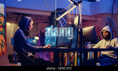 Hackers in hidden shelter excited after managing to launch successful DDoS attack on website, celebrating being able to it crash by sending large amounts of traffic from multiple sources. Stock Photo