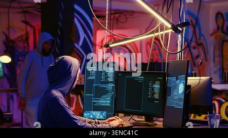 Hackers in underground hideout discussing technical knowhow details before using bugs and exploits to break into computer systems and access valuable data, finding best approach to bypass firewalls. Stock Photo