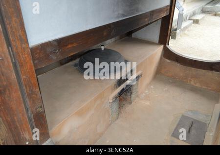 A traditional Korean kitchen hearth with an iron cauldron and wood-fired stove is preserved inside a historic hanok building in Gangneung, South Korea Stock Photo