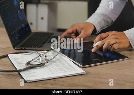 Healthcare business intelligence dashboard analysis on laptop and tablet with medical records. Data visualization, KPI monitoring, healthcare analytic Stock Photo