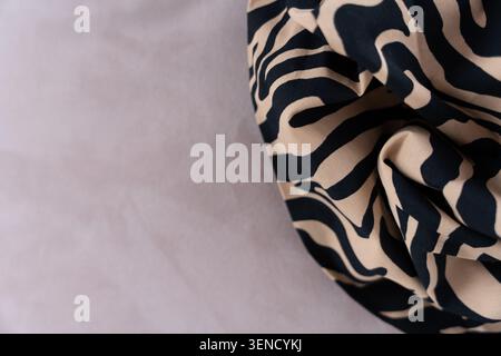 Zebra print fabric with beige and black pattern on soft background, close-up with copy space Stock Photo