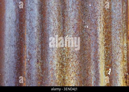 Weathered corrugated metal surface with rust oxidation and aged industrial texture featuring detailed patterns and rugged character for background use Stock Photo