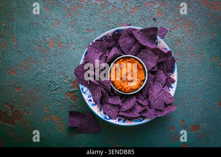 Violet tortilla chips with red salsa Stock Photo