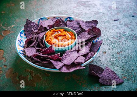 Violet tortilla chips with red salsa Stock Photo