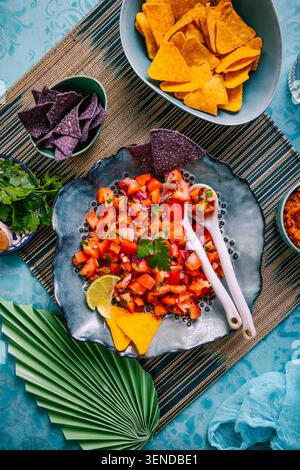 Traditional Mexican tomato salad with lime, onions and nachos with assorted dips Stock Photo