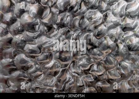 Abstract hammered stainless steel texture with organic reflective pattern, polished metallic surface background featuring irregular industrial finish Stock Photo
