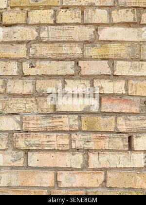 Texture of Weathered Antique Brick Wall with Yellow and Pinkish Blocks Background. Stock Photo