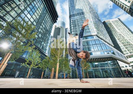 A sporty businessman stands upside down – a business concept of inversion in finance. Flexible and different in the business concept. Stock Photo