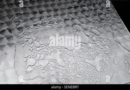 rain drops on patterned metal cafe table top, yorkshire, england Stock Photo
