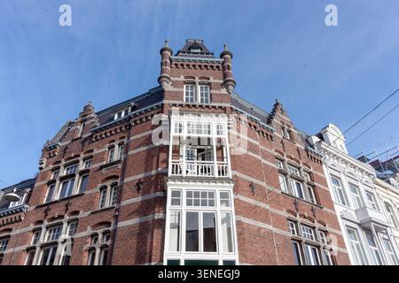 MAASTRICHT, NETHERLANDS - NOVEMBER 12, 2025: Historic red brick corner building with ornate white window frames in Maastricht Stock Photo