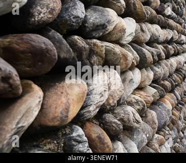 Close view of stacked stone wall showcasing texture craftsmanship and traditional construction Stock Photo