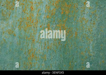 Corroded metal surface with faded paint and rust stains. Distressed industrial texture suitable for backgrounds, overlays and design projects. Stock Photo