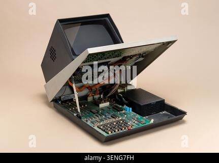 Pavia, Lombardy, Italy - November 2, 2024: Sharp MZ-80K 1979 open on beige background. Lid raised showing motherboard, Z80 CPU, chips and wiring. Icon Stock Photo