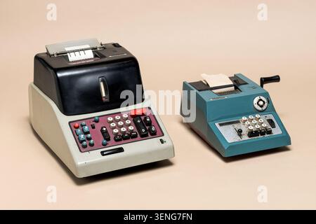 Pavia, Lombardy, Italy - November 2, 2024: Olivetti Divisumma 24 ,1956, and Summa Prima 20 , 1960, vintage calculators on beige background. Italian in Stock Photo