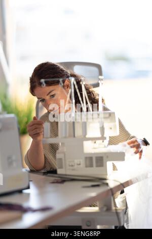Crafting clothing with sewing machine during day time in bright workspace Stock Photo