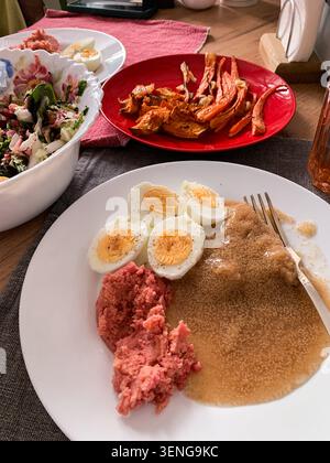 A healthy breakfast spread includes amaranth porridge, boiled eggs, beetroot hummus, baked vegetables, and a fresh salad. The meal is served on a neat Stock Photo