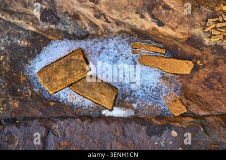 Snow and Sandstone Slabs on Rugged Rock Surface in Nevada Desert Stock Photo