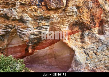 Sandstone Rock Formation Red Stripes and Erosion Patterns Desert Vegetation Stock Photo