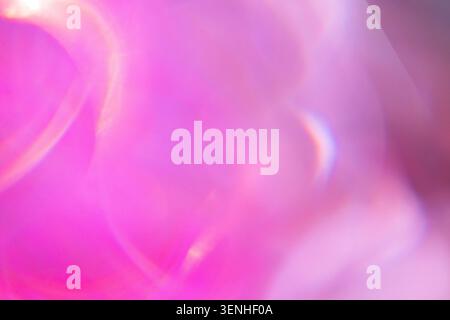 Abstract image showcasing a blurred background with pink and purple colors, highlighted by soft light reflections and circular bokeh effects Stock Photo