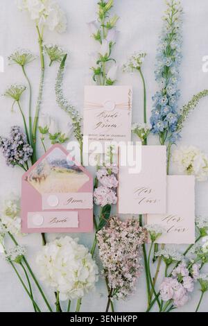 Elegant wedding invitation suite among pastel flowers Stock Photo
