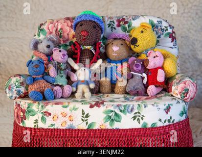 Mr Brown Bear and all his family huddle together on the sofa, ready for their favourite TV programme—a cosy celebration of family and friendship. Stock Photo