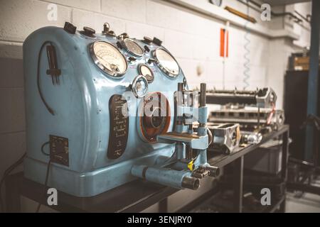 A detailed view of an old-fashioned blue electrical testing apparatus featuring multiple analog meters and various switches for diagnostics Stock Photo