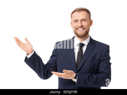 Smiling young businessman in dark blue suit presenting product or service with open hands, professional corporate communication Stock Photo
