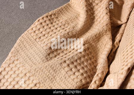 Textured beige waffle weave fabric detail, soft cotton material, cozy home textile background Stock Photo