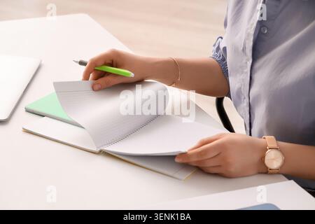 Student or business professional turning pages of spiral notebook with pen, learning, planning, and organization Stock Photo