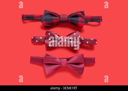 Different stylish bow ties on red background Stock Photo