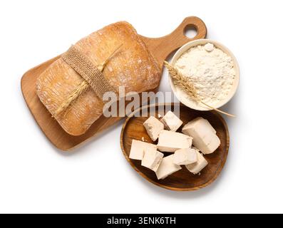 Freshly baked ciabatta bread with wheat flour and yeast blocks on white background, baking ingredients, these essential baking ingredients are arrange Stock Photo
