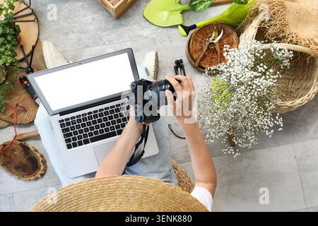 Overhead view of person editing photos on laptop with camera and gardening tools, creative hobby and digital workflow, the scene combines digital work Stock Photo
