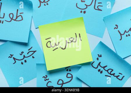 Arabic language learning with handwritten words on colorful sticky notes for education and communication, the notes are scattered on a light backgroun Stock Photo
