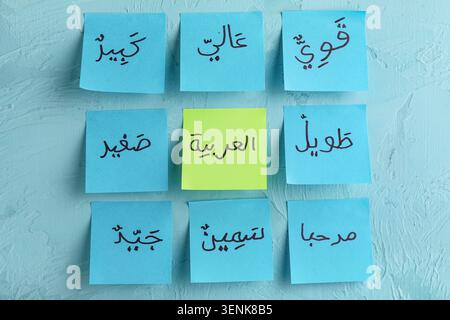 Arabic language learning with sticky notes on blue background, education and communication Stock Photo