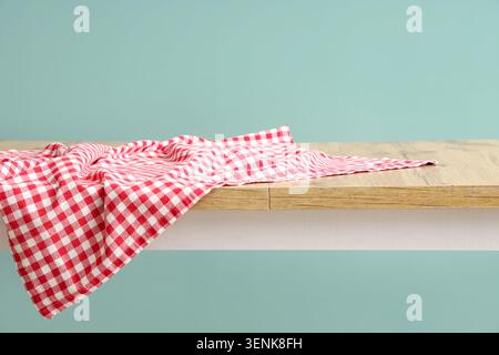 Red and white gingham checkered tablecloth on wooden table with copy space, kitchen and dining background Stock Photo