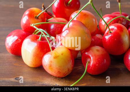 Ripe sweet cherries lie on a wooden background. Stock Photo