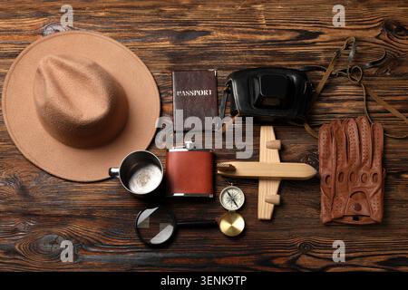 Travel adventure flat lay with passport, camera, hat, and compass on rustic wooden background Stock Photo