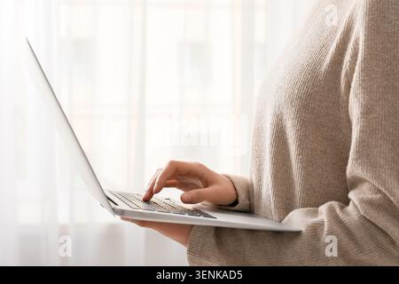 Womans hand typing on laptop keyboard, remote work and online communication, digital technology and internet connectivity Stock Photo