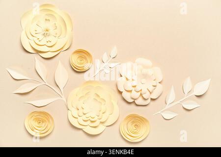 Elegant cream paper flowers and leaves arrangement on textured background for craft and decoration, this elegant composition features various sizes an Stock Photo
