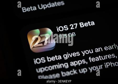 Close-up of an iPhone screen displaying iOS 27 beta update information in the settings menu, including automatic updates and developer beta options Stock Photo