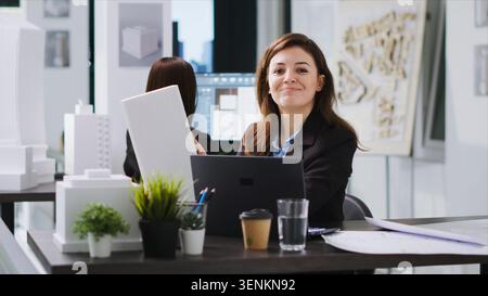 Architect examines 3D model scale to gather dimensions and create industrial blueprint for property remodeling project. CAD specialist working on engineering plan. Handheld shot. Stock Photo