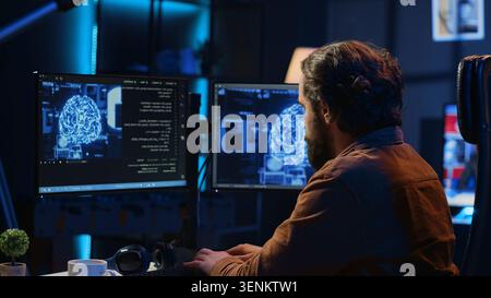 Developer updating artificial intelligence neural networks, typing on computer keyboard in neon lit personal office. Freelancing IT specialist writing AI code, training machine learning, camera A. Stock Photo