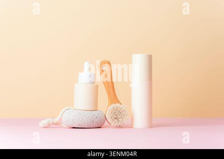 Skincare products with facial brush, pumice stone and cosmetic bottles on pastel background, beauty and wellness arrangement with copy space. Stock Photo