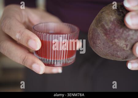 Holding beetroot and juice in hand for healthy drinks Stock Photo