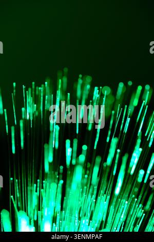 Futuristic abstract background featuring glowing green fiber optic light lines in close up view Stock Photo