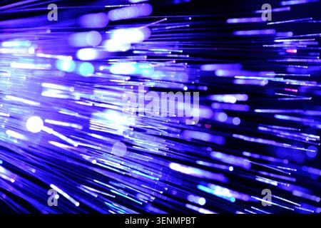 Dynamic horizontal abstract motion blur of bright blue and violet fiber optic lights on black Stock Photo