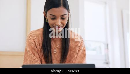 Creative, online and happy woman with laptop on bed, freelancer and video editing on web in bedroom. Editor, home and Indian person with tech, remote Stock Photo