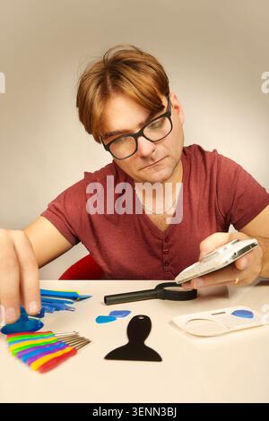 Man working on repairing of broken smartphone with zoom lens Stock Photo
