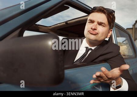 Man in black suit driving his lovely retro car Stock Photo
