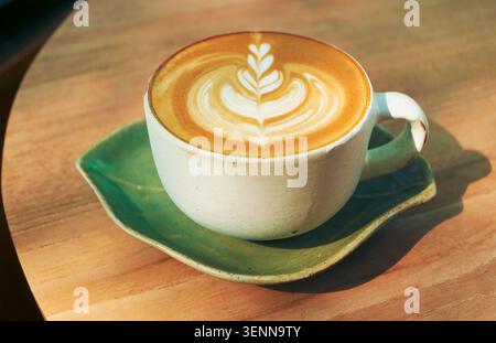Cup of cappuccino coffee with heart shaped latte art isolated in the morning light Stock Photo